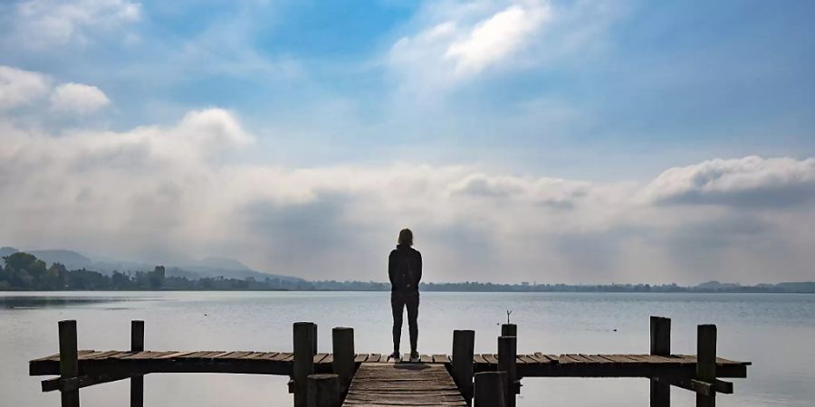 Eine Frau steht bei sommerlichem Septemberwetter rauf einem Steg auf dem Pfäffikersee im Zürcher Oberland. (Archivbild)