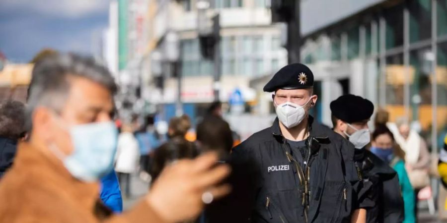 Bundespolizisten kontrollieren auf einer Einkaufsstrasse in Berlin die Einhaltung der Maskenpflicht. Foto: Christoph Soeder/dpa