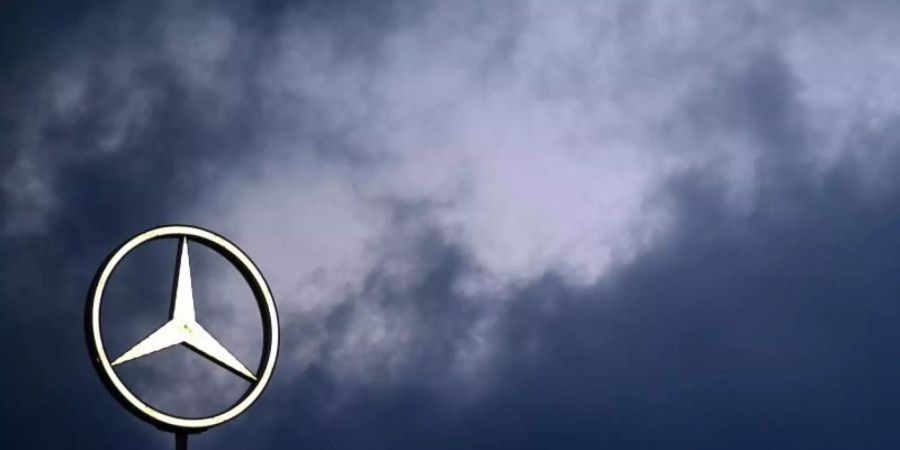 Der Mercedes-Stern vor dem dunklen Himmel. Foto: Sebastian Gollnow/dpa