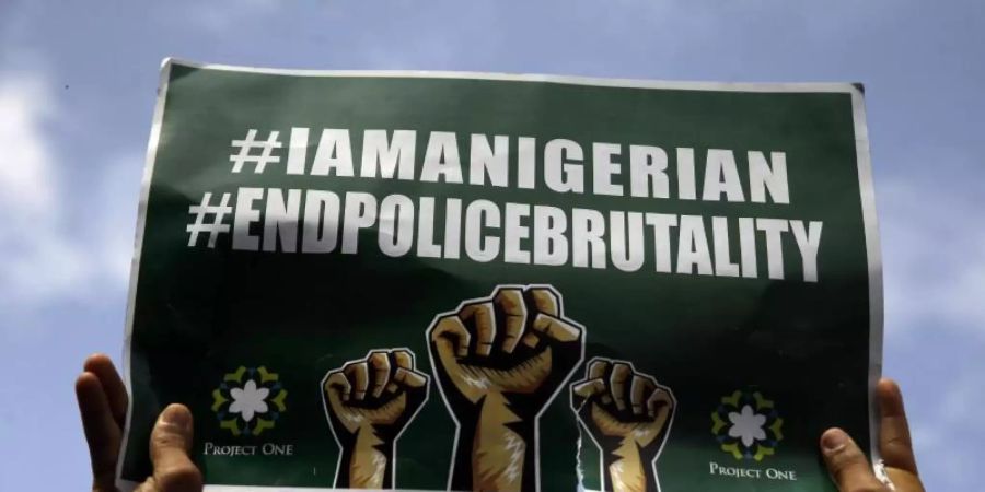 Menschen demonstrieren in Lagos mit Transparenten auf der Strasse gegen die Brutalität der Polizei. Foto: Sunday Alamba/AP/dpa