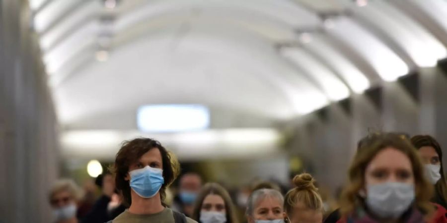 Pendler mit Schutzmasken in einer Moskauer Metrostation