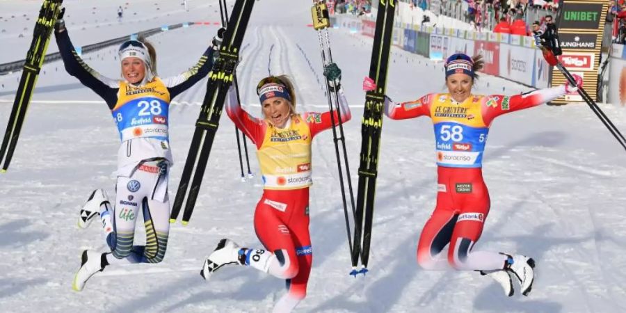 Therese Johaug (M) und Ingvild Flugstad Östberg (r) und Frida Karlsson feiern in Seefeld ihre Langlauf-Medaillen. Foto: Hendrik Schmidt
