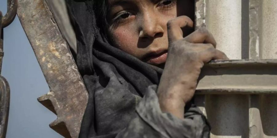 Ein Kind fährt auf einem Lastwagen, der Zivilisten und Familienangehörige von IS-Kämpfern aus der letzten Bastion der Terrormiliz im ostsyrischen Baghus in ein Zwischenlager bringt. Foto: Aboud Hamam