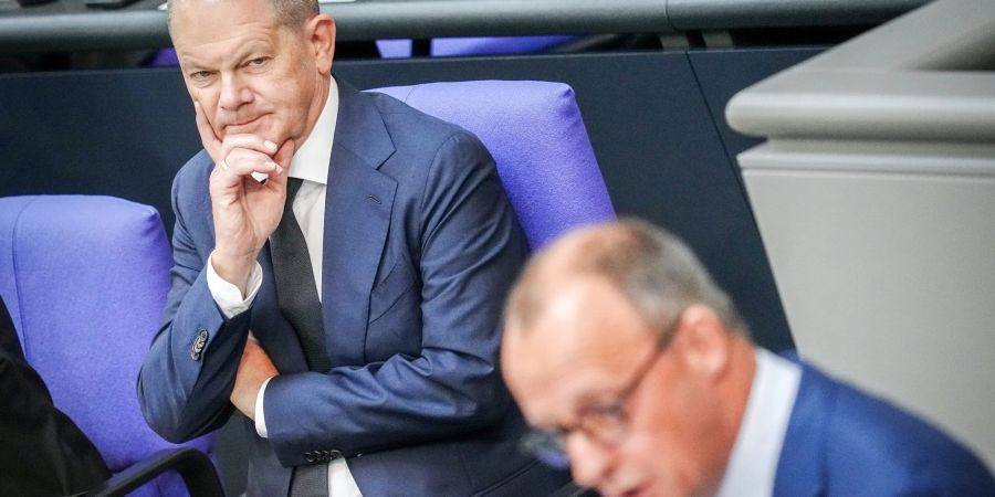 CDU-Chef Friedrich Merz (r) spricht neben Bundeskanzler Olaf Scholz (SPD) im Plenum des Bundestags (Archivbild).