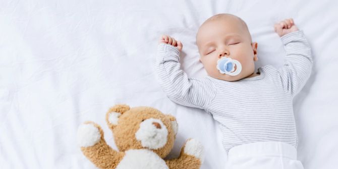 Baby schläft mit Teddy