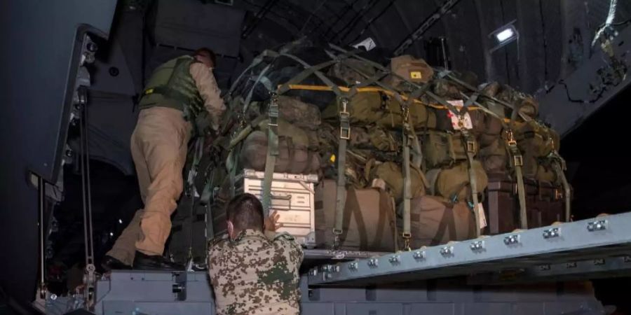 Soldaten der Bundeswehr laden in Masar-i-Scharif Gepäckstücke in ein Transportflugzeug A400M der Luftwaffe. Foto: Torsten Kraatz/Bundeswehr/dpa