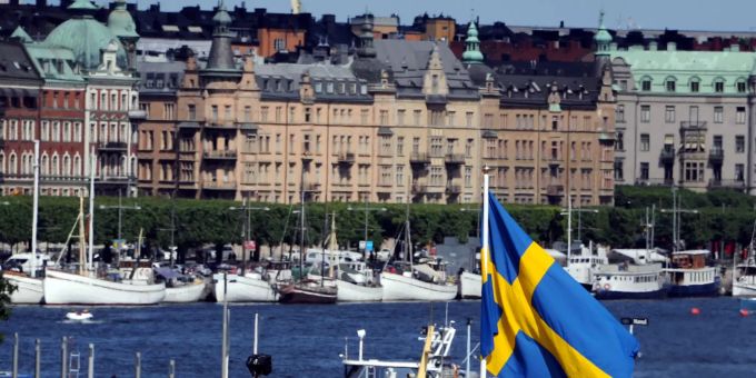 Blick auf Altbauten und die Nationalflagge in der schwedischen Hauptstadt. Stockholm