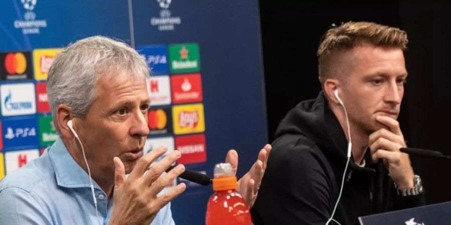 BVB-Trainer Lucien Favre (l) und Marco Reus bei der Pressekonferenz vor dem Spiel gegen den FC Barcelona. Foto: Bernd Thissen