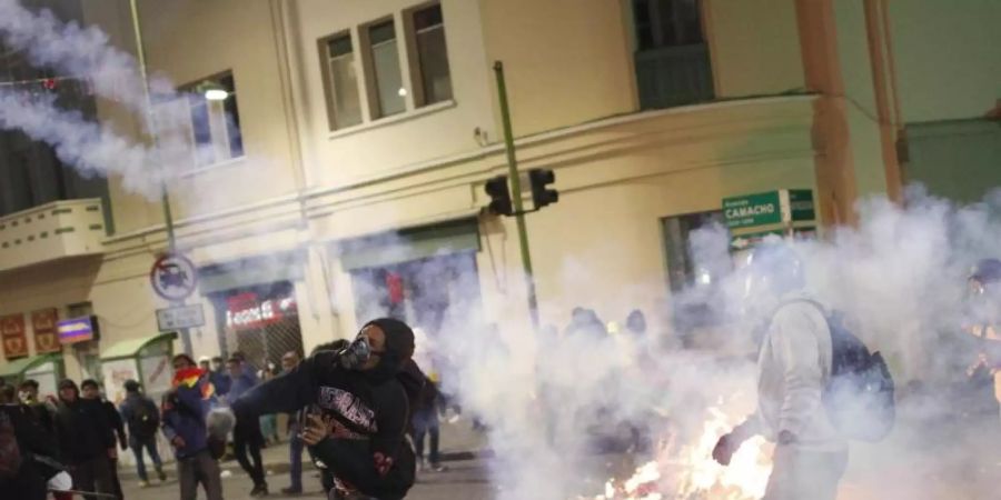 Regierungskritische Demonstranten stossen während eines Protests gegen die Wiederwahl von Präsident Morales mit der Polizei zusammen. Foto: Juan Karita/AP/dpa