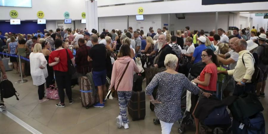 Britische Touristen warten im Flughafen auf Korfu auf Antworten.