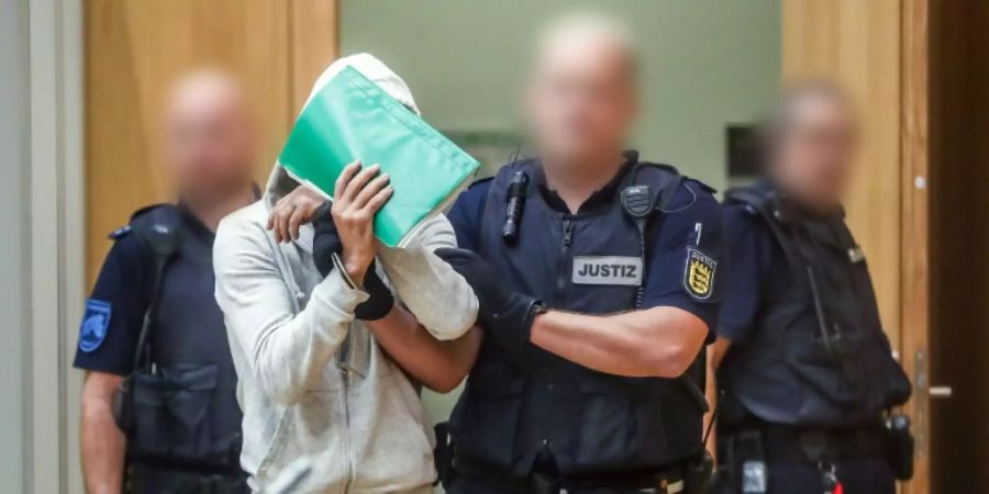 Der Angeklagte wird in den Gerichtssaal geführt