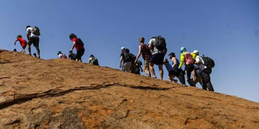 Für viele Australien-Urlauber ist es ein Muss, den Uluru im Uluru-Kata Tjuta Nationalpark zu besteigen. Der Zutritt zu dem Felsen wird ab dem 26. Oktober 2019 jedoch verboten. Foto: Lukas Coch/AAP/dpa