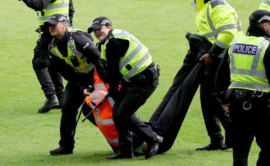 Hier wird ein verletzter Stadion-Ordner vom Feld getragen.