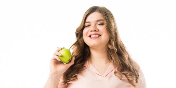 Lächelnde Frau mit Apfel in der Hand