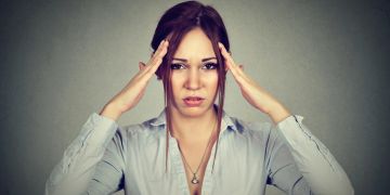 frau hält sich den kopf