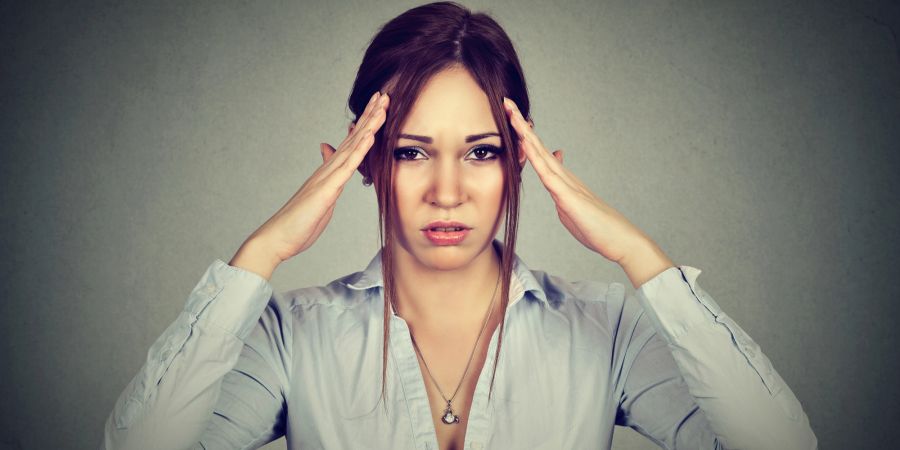 frau hält sich den kopf