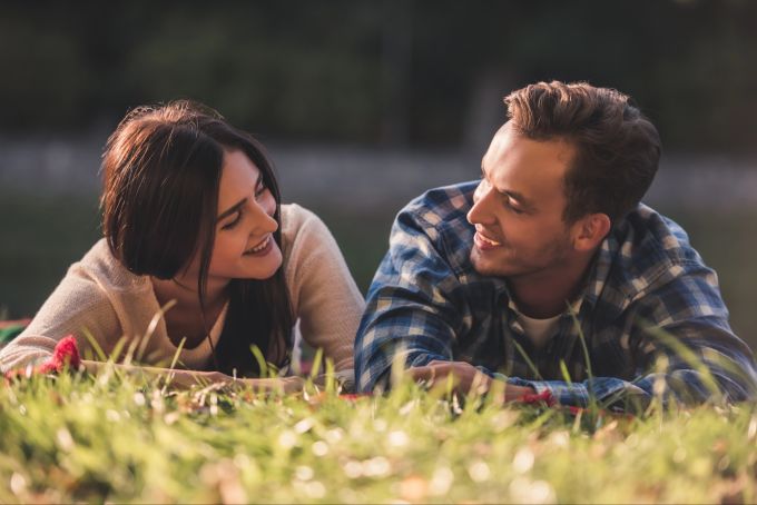 Gemeinsame Zeit, die bewusst erlebt wird, ist für viele Paare eine bedeutende Liebessprache. Paar auf einer Wiese