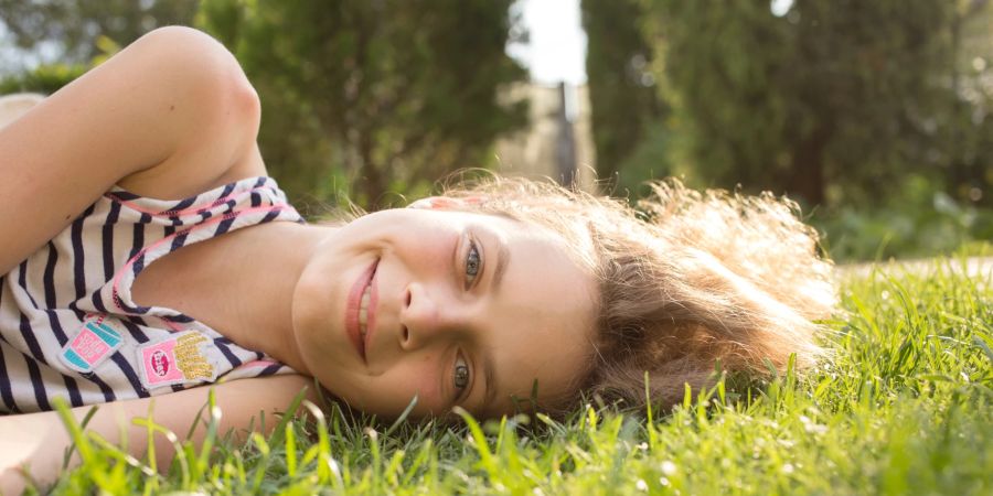 mädchen liegt im gras