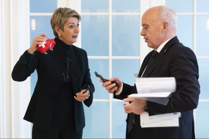 Der zurückgetretene Bundesrat Ueli Maurer, rechts, übergibt seiner Nachfolgerin im EFD, Bundesrätin Karin Keller-Sutter, ein Sparschwein, einen Sparschäler und die Tresorschlüssel, bei der Schlüsselübergabe im EFD am 20. Dezember 2022. Ueli Maurer Karin Keller-Sutter