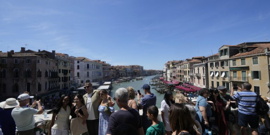 ARCHIV - Viele Touristen stehen auf der Rialto-Brücke in Venedig. Foto: Luca Bruno/AP/dpa