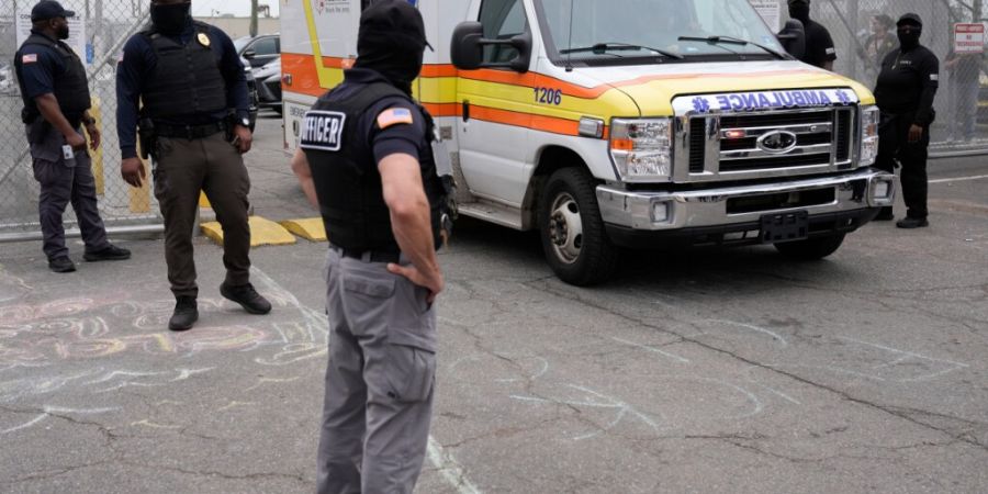 ARCHIV - Beamte der US-Einwanderungsbehörde (ICE) stehen vor der Haftanstalt Delaney Hall, als ein Krankenwagen das Gelände verlässt. Foto: Seth Wenig/AP/dpa/Archivbild