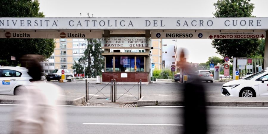 Passanten gehen am Haupteingang der Poliklinik «Agostino Gemelli» vorbei, in der Papst Leo XIV. in den nächsten Tagen zur Entfernung eines Lungenknotens stationär aufgenommen werden s...