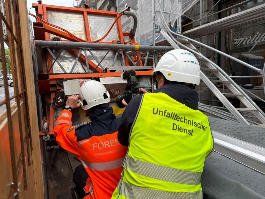 Mitarbeitende des Forensischen Instituts und des Unfalltechnischen Dienstes untersuchen den abgestürzten Baustellenlift nach dem schweren Unfall an der Hafnerstrasse.
