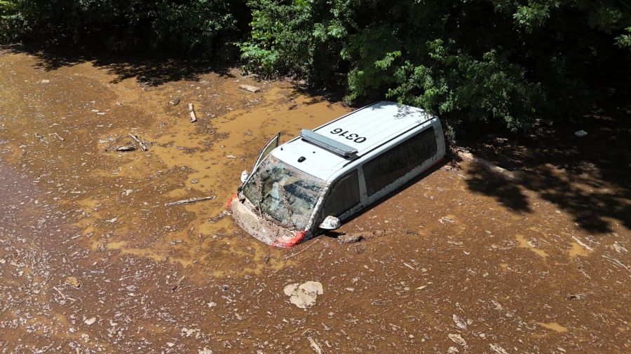 Die Hälfte des Polizeiautos steckt am Samstagmittag noch im schlammigen Fluss.