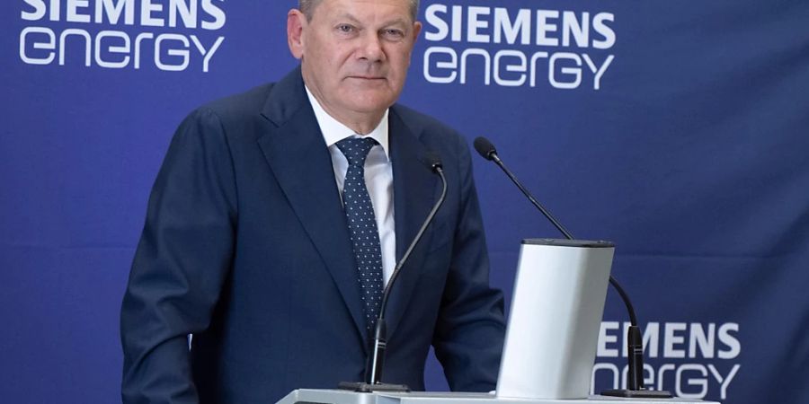 Bundeskanzler Olaf Scholz (SPD) spricht bei Siemens Energy neben der in Kanada für die Erdgas-Pipeline Nordstream 1 gewarteten Turbine. Foto: Bernd Thissen/dpa