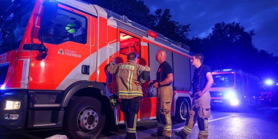 Feuerwahrfahrzeuge stehen mit Blaulicht auf der Abfahrt der Autobahn A115.