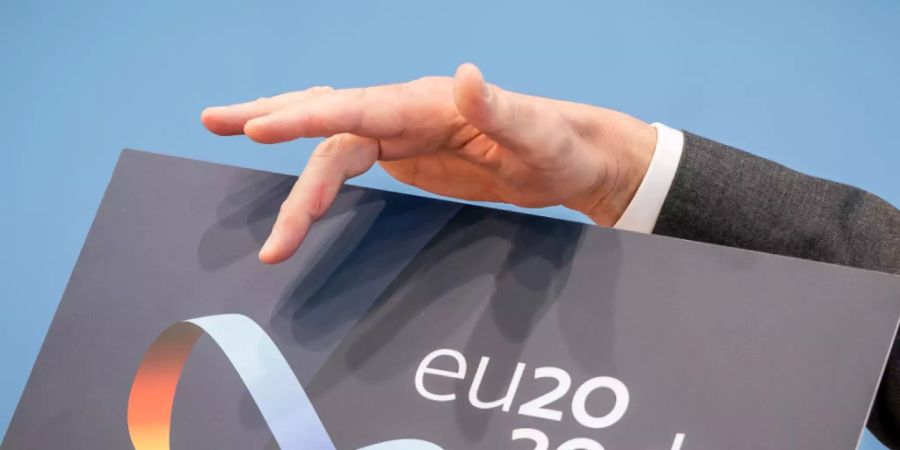 Steffen Seibert, Sprecher der Bundesregierung, zeigt das Logo der Deutschen EU-Ratspräsidentschaft. Vom 01.07. an übernimmt Deutschland die EU-Ratspräsidentschaft unter dem Motto «Gemeinsam. Europa wieder stark machen». Im Logo ist ein Möbiusband zu sehen - ein Symbol für Einigkeit und Verbundenheit. Foto: Michael Kappeler/dpa