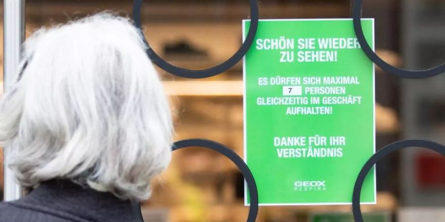 Ein Hinweisschild in Stuttgart weist auf die bislang gültigen Zutrittsbeschränkungen in einem Geschäft hin. Foto: Tom Weller/dpa