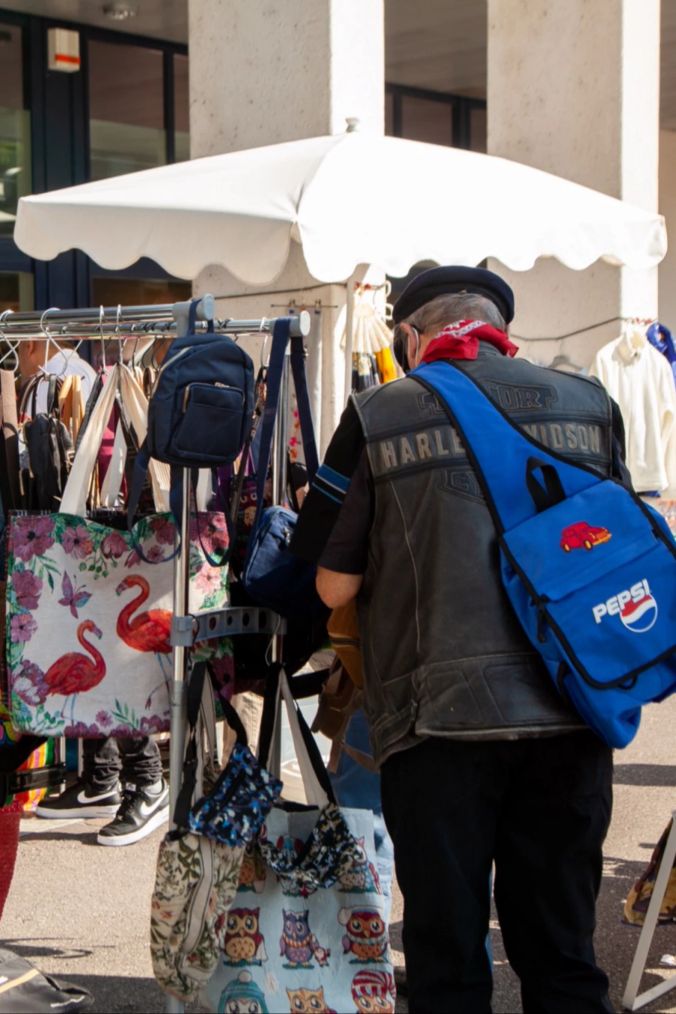 Neugiere durchforschen die Kleiderstangen am Flohmarkt