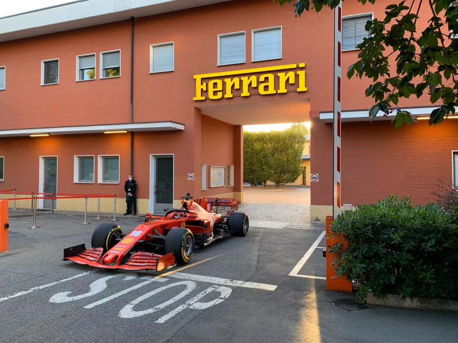 Charles Leclerc fährt den Ferrari SF1000 durch das Tor der alten Ferrari-Werke in Maranello.