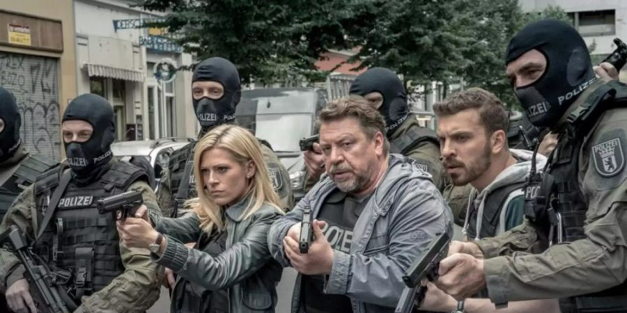 Lola Karras (Nele Kiper), Fredo Schulz (Armin Rohde) und Milan Filipovic (Edin Hasanovic) stehen mit gezogenen Waffen zwischen SEK-Beamten (l-r). Foto: Nik Konietzny/ZDF/dpa