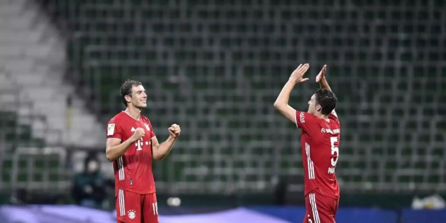 Bayerns Leon Goretzka (l) und Benjamin Pavard bejubeln den feststehenden Gewinn der Meisterschaft. Foto: Martin Meissner/AP-Pool/dpa