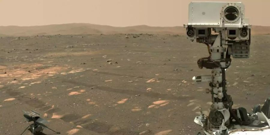 Der US-Rover «Perseverance» (r) neben dem Mini-Hubschrauber «Ingenuity» auf dem Mars. Foto: NASA/JPL-Caltech/MSSS/dpa