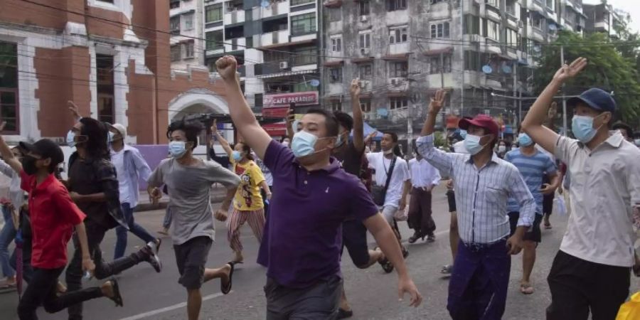 Anti-Putsch-Demonstranten zeigen das Drei-Finger-Zeichen des Widerstandes während eines Flashmobs in Yangon. Foto: -/AP/dpa