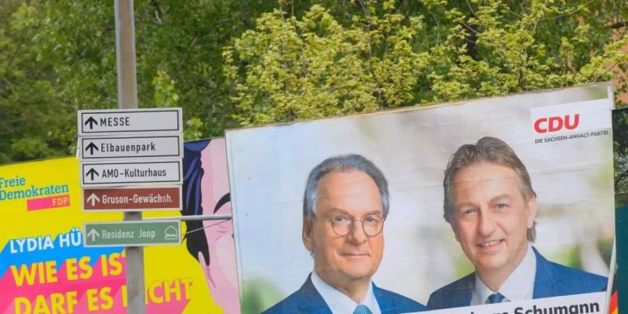 Reiner Haseloff (auf dem Plakat links) ist mit 67 im Rentenalter. Und im Karrierehoch. Foto: Klaus-Dietmar Gabbert/dpa-Zentralbild/dpa