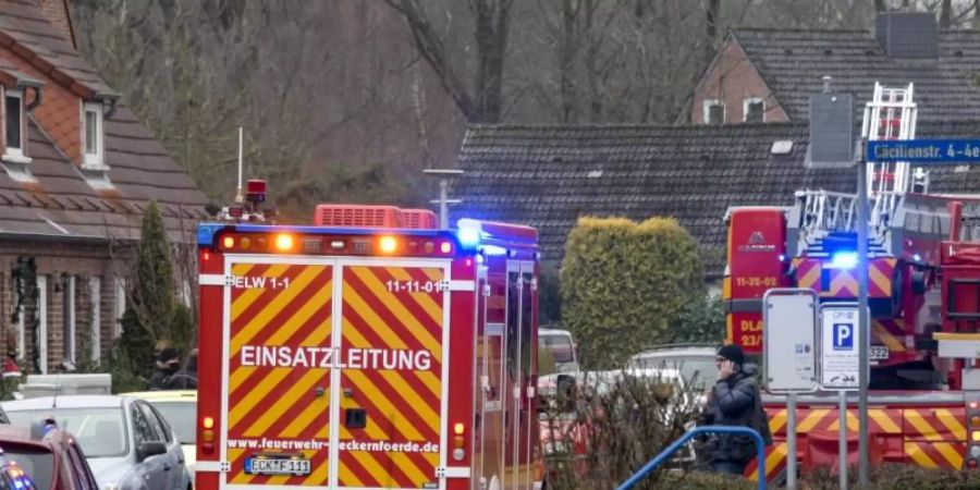 Einsatzkräfte von Polizei und Feuerwehr stehen neben einem Haus in Eckernförde, in dem sich ein junger Mann beim Herstellen von Böllern schwer verletzt hat. Foto: Axel Heimken/dpa