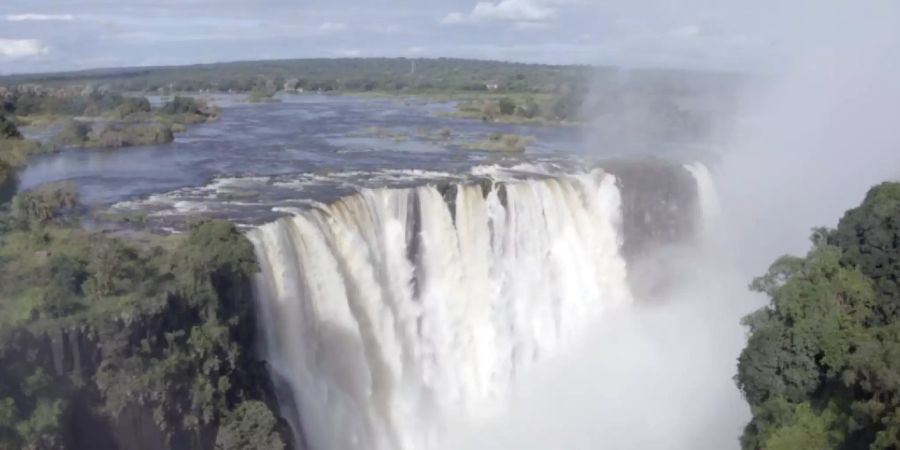 Die angeblich ausgetrockneten Victoria-Wasserfälle werden nun von Wasser überströmt, doch der Tourismus bleibt wegen der Pandemie aus. Foto: Columbus S. Mavhunga/dpa - ACHTUNG: Nur zur redaktionellen Verwendung im Zusammenhang mit der aktuellen Berichterstattung und nur mit vollständiger Nennung des vorstehenden Credits