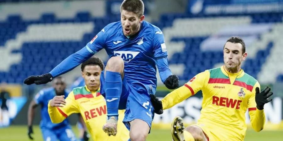 Kölns Ismail Jakobs (l-r), Hoffenheims Andrej Kramaric und Kölns Ellyes Skhiri kämpfen um den Ball. Foto: Uwe Anspach/dpa