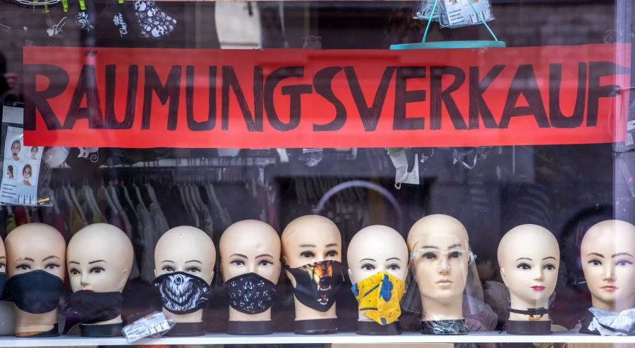 Schaufensterpuppen-Köpfe mit verschiedenen Mund-Nasen-Masken stehen im Schaufenster eines Geschäftes, das einen Räumungsverkauf anbietet. (Archivbild)