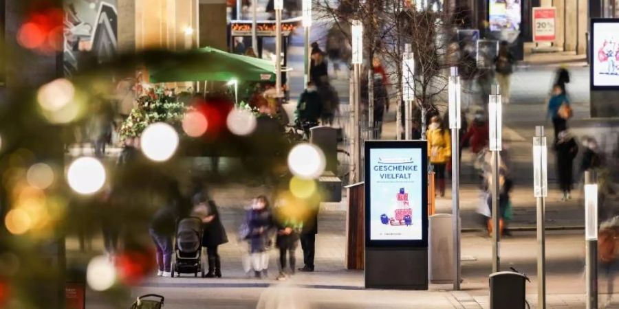 Passanten gehen durch die Fussgängerzone in der Petersstrasse in der Leipziger Innenstadt. In Sachsen gelten nun unter anderem Ausgangsbeschränkungen. Foto: Jan Woitas/dpa-Zentralbild/dpa