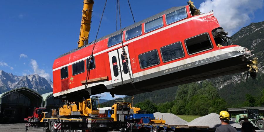 Ein auseinandergeschnittenes Waggonteil wird nach dem tödlichen Zugunglück in Garmisch-Partenkirchen vom Laster gehoben und gelagert.