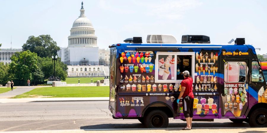 Ein Eisverkäufer vor dem US-Kapitol: Heute stimmen die Parlamentarier über ein umfassendes Gesetzespaket ab, das auch der hohen Inflation entgegenwirken soll.