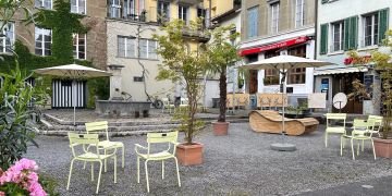 Stühle und Sonnenschirme auf einem Platz