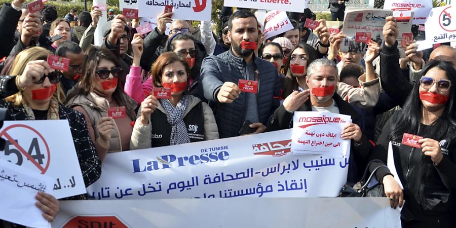 ARCHIV - Journalisten zeigen in Tunis ihre Presseausweise, um gegen die Gefahr, die der Presse droht und die Rückkehr zu einer Diktatur zu demonstrieren. Zuvor war der Chef eines für kritische Berichte bekannten Radiosenders festgenommen worden. Foto: Hassene Dridi/AP/dpa