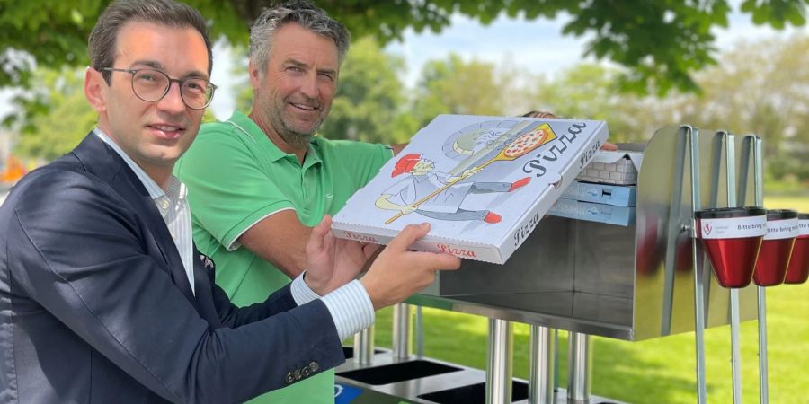 Zwei Männer an einer Recyclingstation.