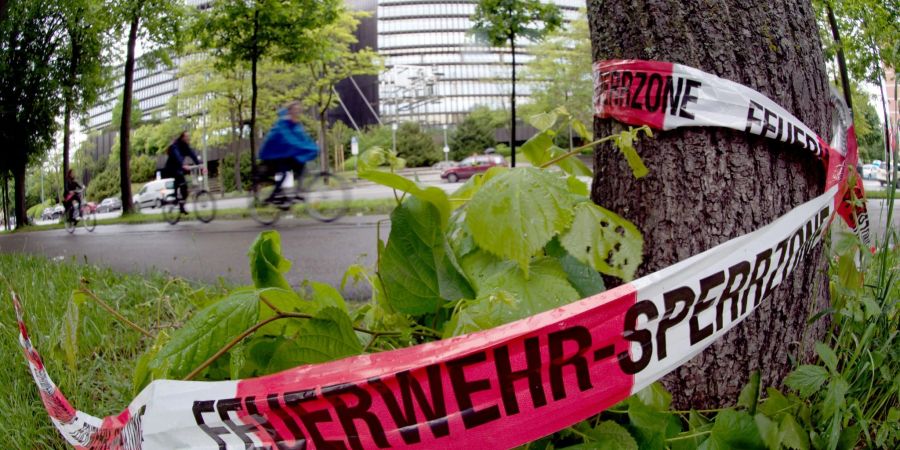 Absperrband der Feuerwehr hängt an einem Baum: Am späten Abend des 28.05.2013 wurde an der Stelle ein 31-Jähriger von einem unbekannten Mann so schwer verletzt, dass er kurze Zeit später im Krankenhaus starb